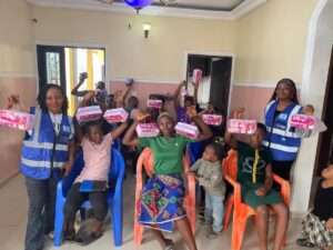 Participants holding sanitary kits at a menstrual hygiene lecture